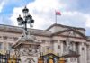 Buckingham Palace facade with Union Jack flag and ornate gate