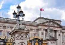 Buckingham Palace facade with Union Jack flag and ornate gate