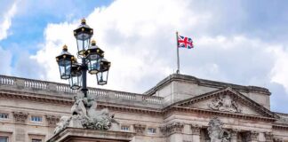 Buckingham Palace facade with Union Jack flag and ornate gate