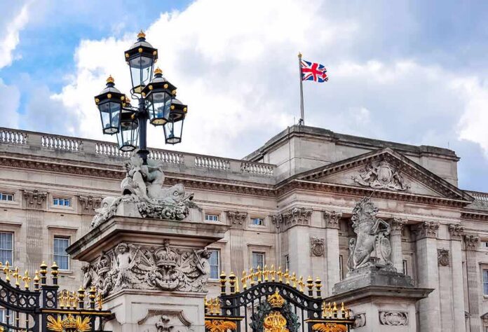 Buckingham Palace facade with Union Jack flag and ornate gate
