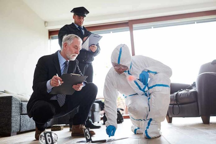 shutterstock_1455188570 Forensic investigator collects evidence as police and detective observe