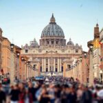 St. Peter's Basilica viewed from a busy street with crowds