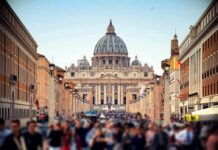 St. Peter's Basilica viewed from a busy street with crowds