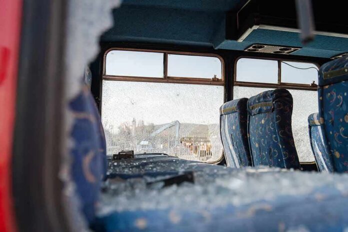 Bus interior with shattered windows and blue patterned seats