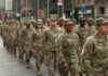 Jason Worilds and Elandon Roberts march with fellow soldiers in a city parade