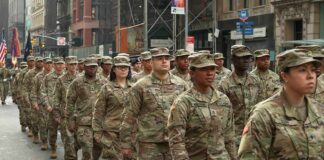 Jason Worilds and Elandon Roberts march with fellow soldiers in a city parade