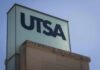 UTSA sign on a building corner against a clear sky