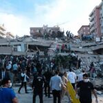 Rescue workers and civilians on collapsed building after earthquake