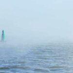 Hormuz Surge Shocks Oil Markets Green buoy in foggy sea