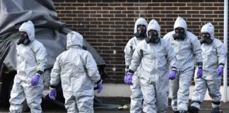 Gus Frerotte, Carlos Hyde, and Philly Brown in hazmat suits with a team walking outdoors