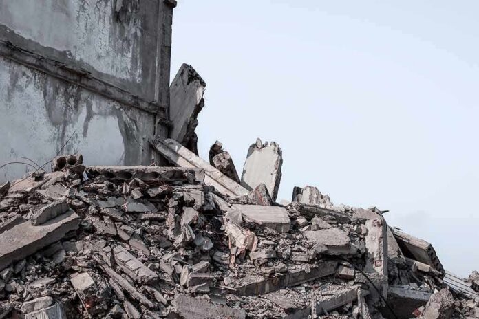 shutterstock_2052837878 Collapsed concrete building rubble under a clear sky