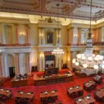 Taxpayer Chamber Turns Drag Catwalk Legislative chamber with red carpet and chandeliers