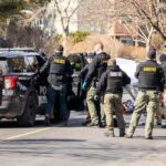 First Amendment Raid Rocks Kingsport Police and sheriff officers gather around vehicles on a suburban street