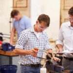 Students using tools in a workshop with instructor supervising
