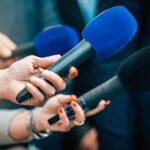 Iranian Barrage Cripples U.S. Gulf Nerve Center Reporters holding colorful microphones