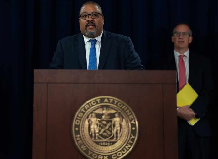Man speaks at podium with New York County District Attorney seal