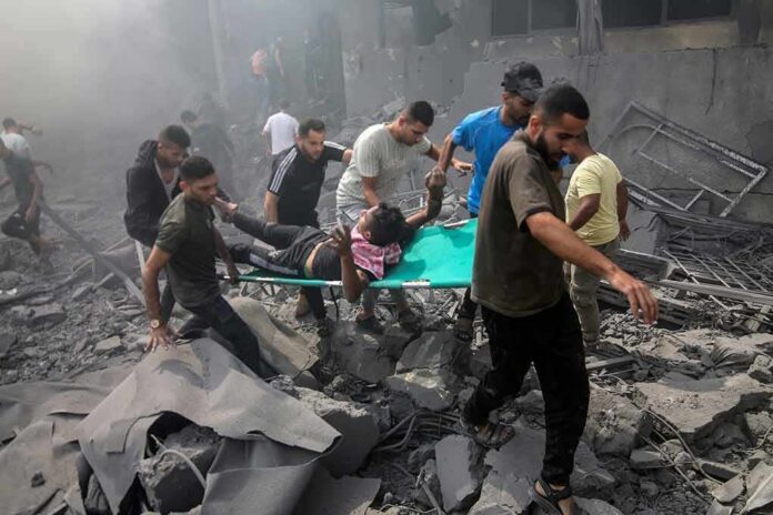 Rescuers carry an injured person on a stretcher through rubble