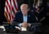 Trump Centralizes Services Under One AI Donald Trump seated at a table between two desk phones
