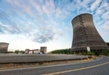Nuclear Near-Miss Stuns Watchdog Cooling towers at an industrial power plant under a partly cloudy sky