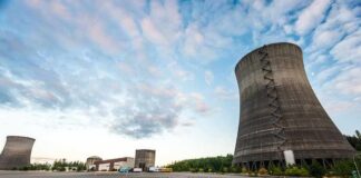 Cooling towers at an industrial power plant under a partly cloudy sky
