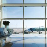 Airport terminal with plane at gate viewed through large windows