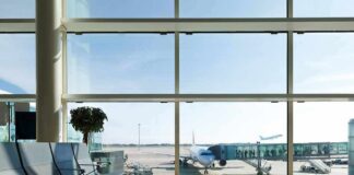 Airport terminal with plane at gate viewed through large windows