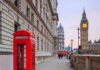 Red telephone box on a London street with clock tower in background
