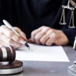 Grand Jury Revolt Rattles D.C. Prosecutors Judge writing at desk with gavel and Lady Justice statue