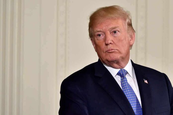 Donald Trump in a dark suit with blue tie looking to the side