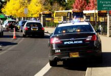 Teen Rampage Shocks Oregon School Police cars with lights on near school buses on a city street