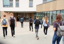 Students with backpacks walking toward a school entrance