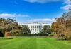 The White House with lawn and gardens under a blue sky