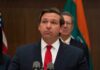 Surprise Reversal Freezes Florida Execution Ron DeSantis at a press conference podium in a suit and red tie