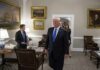 Donald Trump walks through an office with Sean Lawler nearby and Mariano Rajoy following behind