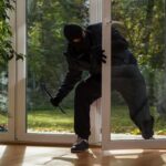 Creepy Rifle Knock-And-Run Stuns Neighborhood A burglar in dark clothing entering a house through a glass door