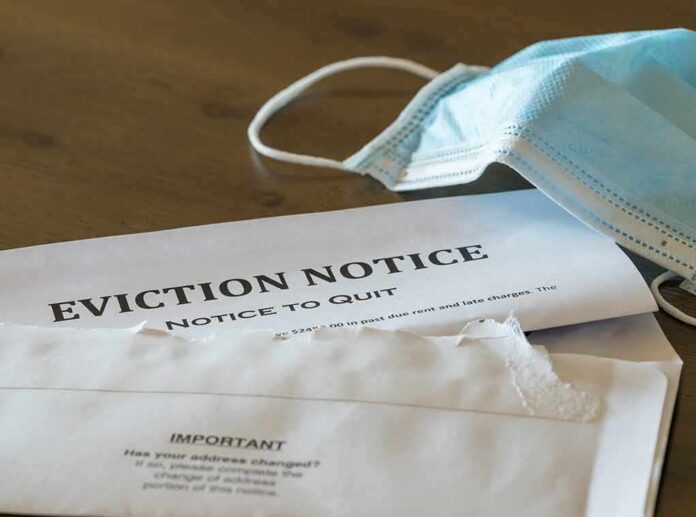 Eviction notice and torn envelope beside blue surgical masks