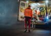 Paramedics load a patient into an ambulance at night