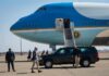 Trump Call Triggers Sudden Release Security detail near blue and white aircraft with staircase and SUV