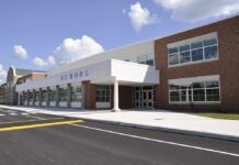 Birthday Gun Twist Upends Oregon Tragedy Modern school building with large windows and a clear sky